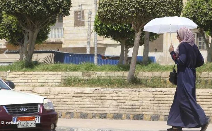 Une femme egyptienne qui porte une ombrelle