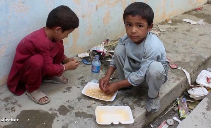 Des enfants afghans pauvres mangent ce que leur donnent les Amricains