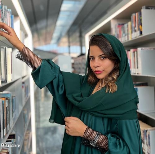 Une jeune femme parcoure les livres d'une bibliothque